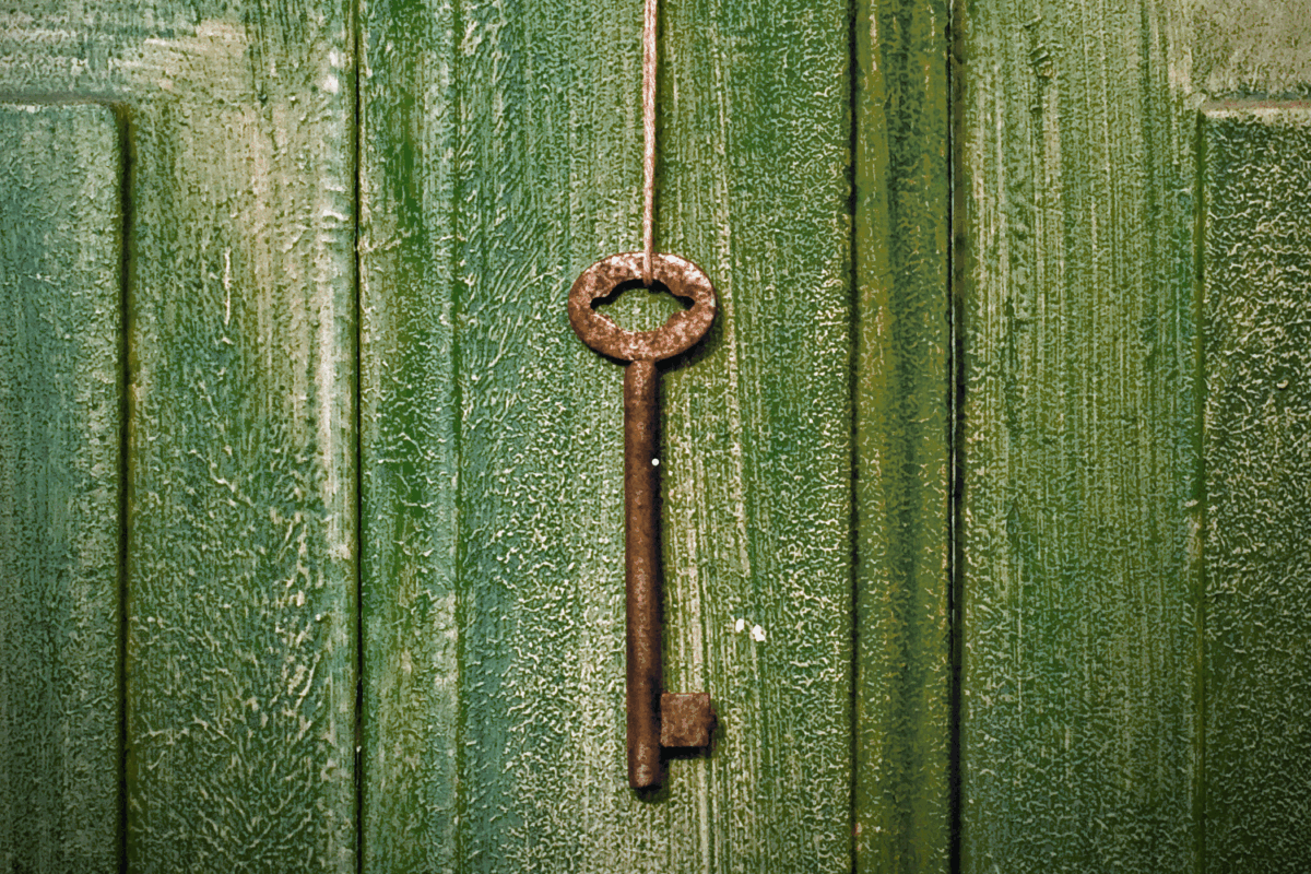 zardzewiały klucz wiszący na sznurku na starych zielonych drzwiach - drzwi bez zamka