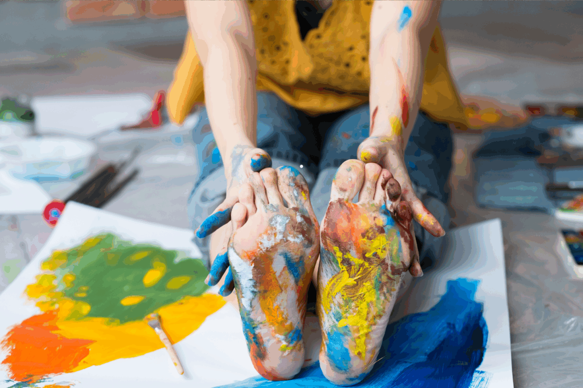 stopy dziecka umazane kolorowymi farbami