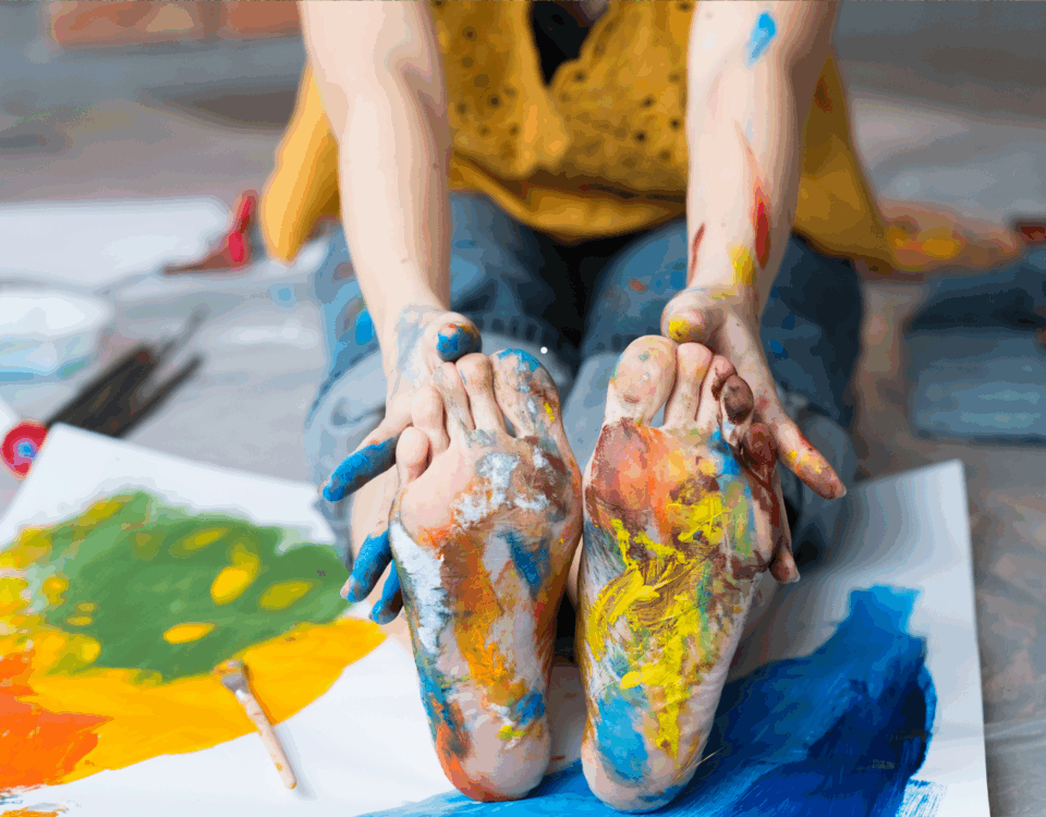 stopy dziecka umazane kolorowymi farbami